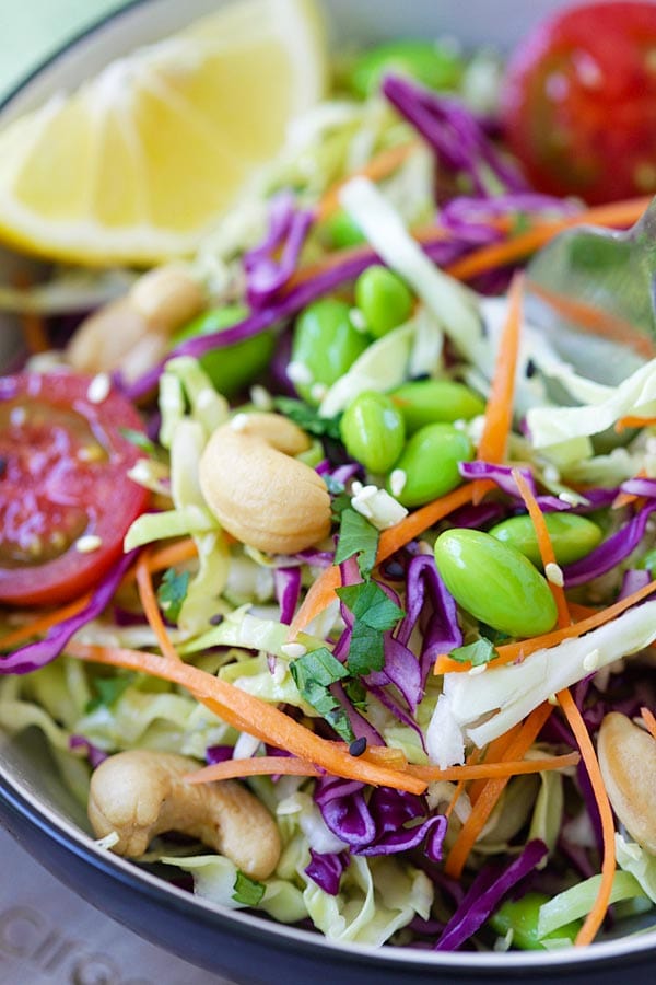Asian slaw recipe with cabbage, red cabbage, edamame, cashew nuts and Asian slaw dressing.