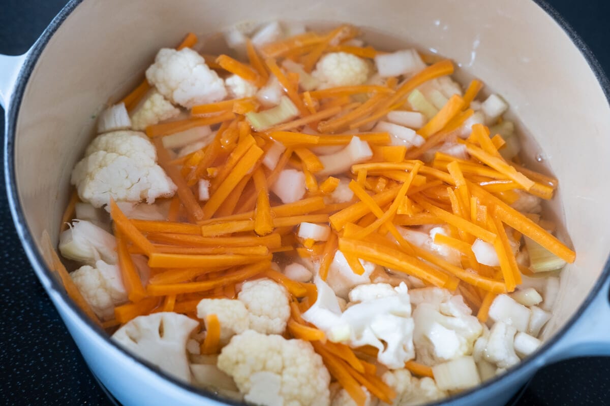 Cauliflower florets, carrots, celery, water, and chicken bouillon in a heavy bottom pot. 