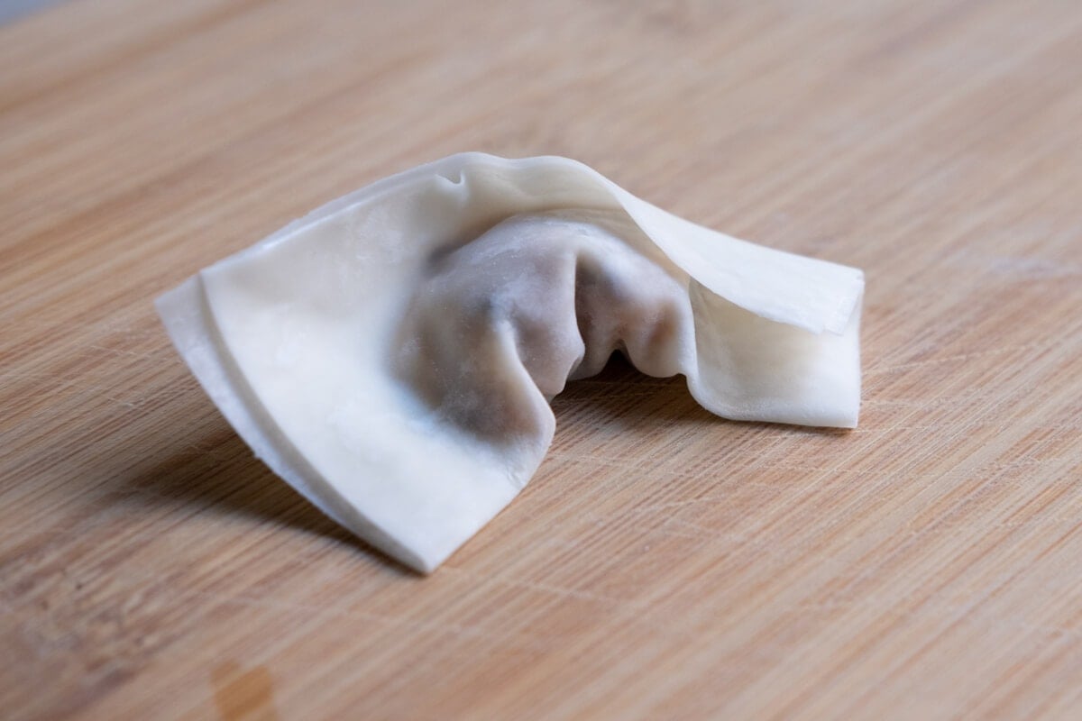 Wonton wrapper filled with chicken wonton filling sealed.
