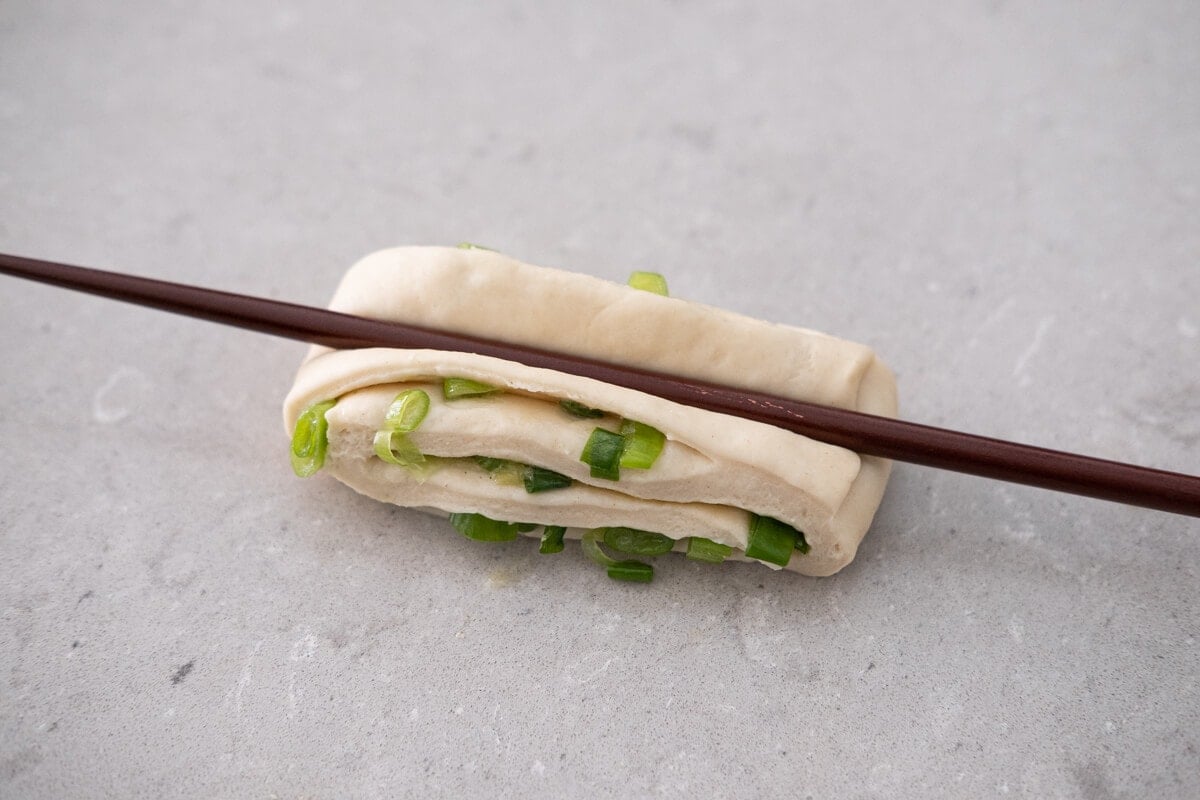 Dough pressed down in the middle with a chopstick.